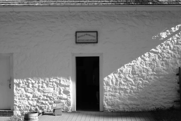 Sunlight and shadows on a whitewashed stone building.